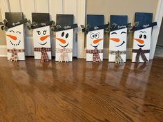 snowmen made out of paper bags sitting on top of a wooden floor