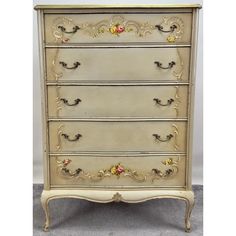 an antique chest of drawers with flowers painted on the top and bottom, in white