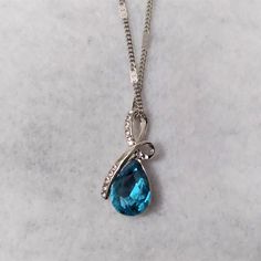 Brand New Luxury Aaaaa Blue Teardrop Cubic Zirconia Pendant Necklace This Lovely White Gold Plated Necklace Has A Large Teardrop Shape Blue Cubic Zirconia Stone That Measures About 1/2 Inch Long By 3/8 Inch Wide. It Has A White Gold Plated "Ribbon" That Loops Around The Top And Has Several Small White Round Stones Along It, Making The Overall Length Of The Pendant About 1 Inch. The Chain Is About 18 Inches With About A 2 Inch Extender And It Is Stamped 18k Gf Indicating It Is 18k Gold Filled. Th Blue Crystal Drop Necklaces, Blue Crystal Drop Necklace, Elegant Blue Teardrop Crystal Necklace, Diamond Jewelry Designs, Pretty Jewelry, Lovely Jewellery, Gold Plated Necklace, Pretty Jewellery, Jewelry Designs