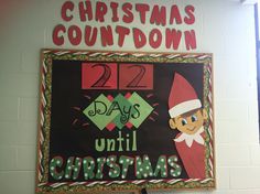 a christmas sign hanging on the side of a wall next to a red and green elf