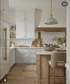 the kitchen is clean and ready for us to use it's white cabinets, wood floors, and counter tops