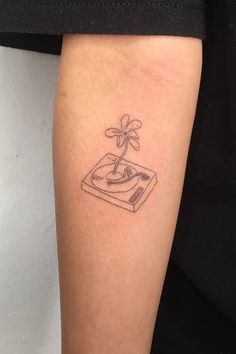 a small tattoo on the leg of a person with a book and flower in it