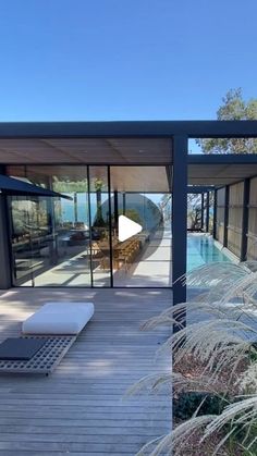 an outdoor deck with chaise lounges next to a swimming pool and patio area