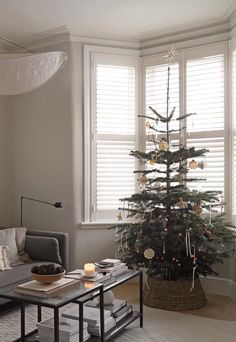 a living room with a christmas tree in the corner and a couch next to it