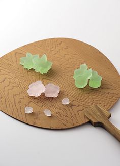 three pieces of glass sitting on top of a wooden paddle