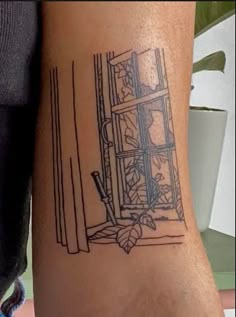 a tattoo on the arm of a person with a window