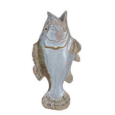 a fish statue sitting on top of a white surface