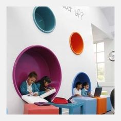 children are sitting in colorful chairs with laptops on their laps and writing at the same time