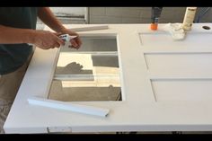 a man is painting a window with white paint