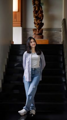 a woman standing in front of some stairs