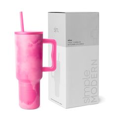 a pink cup with a straw in it next to a box