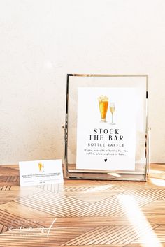 a wooden table topped with a glass of beer next to a business card and envelope