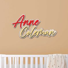 the name ame coleman in red and yellow on a wall above a crib