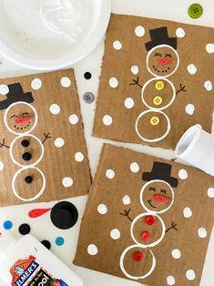 three brown paper bags with snowmen on them and buttons in the shape of circles