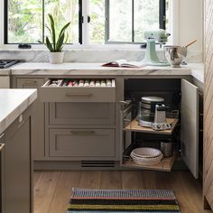 an open cabinet in the middle of a kitchen