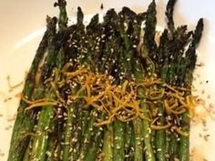 asparagus with sesame seeds and mustard on a white plate