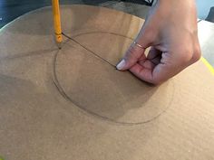 a person is making a circle out of cardboard