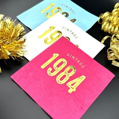 three different colored cards with gold numbers on them next to some tinsel and decorations