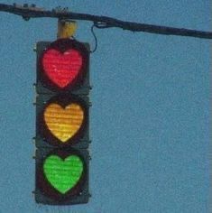 a traffic light with hearts painted on it's red, yellow and green lights