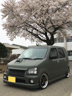 a grey van parked in front of a tree