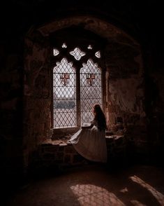 a woman standing in front of a stained glass window