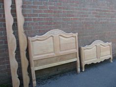 two wooden beds sitting next to each other on the side of a brick wall in front of a building