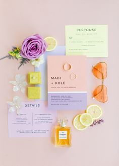 the wedding stationery is laid out with flowers, lemons, and other items