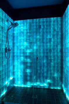 a tiled shower with blue lights on the walls