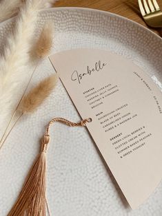 a white plate topped with a tasseled menu