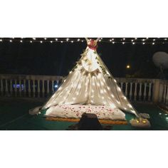 a teepee is lit up with fairy lights