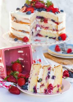 two slices of cake on plates with strawberries and blueberries in the middle one slice is missing