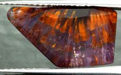 an orange and purple piece of glass sitting on top of a window sill,