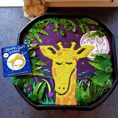 a tray that has some plants in it and a giraffe drawn on it