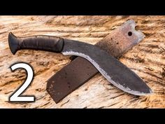 a knife that is laying on top of a wooden table with the number two in front of it