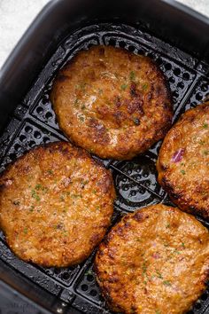 four cooked hamburger patties in an air fryer