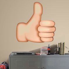 a hand giving the thumbs up sign in front of a locker