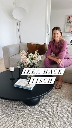 a woman sitting on top of a couch next to a coffee table