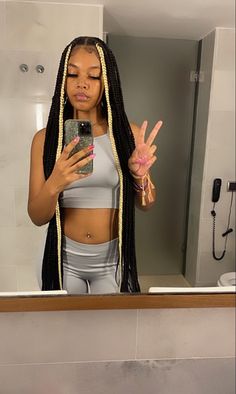 a woman with dreadlocks taking a selfie in front of a bathroom mirror