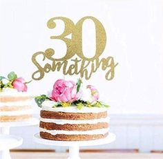 a cake sitting on top of a white plate next to two cakes with gold lettering