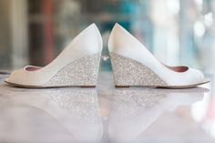 a pair of white high heel shoes with glittered heels on the bottom and side