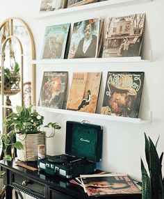 there are many books on the shelves above the desk and in front of it is a record player