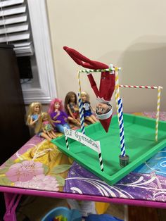 a group of dolls sitting on top of a green table next to a plastic tray