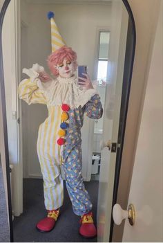 a clown is taking a selfie in the mirror