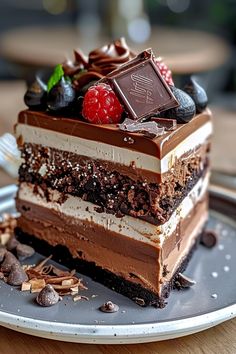 a piece of cake on a plate with chocolate and raspberries