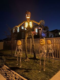 halloween decorations in the yard with skeletons and jack - o'- lantern faces on them