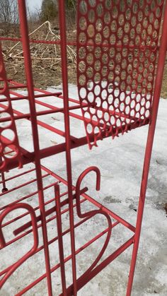 a red metal structure sitting on top of snow covered ground