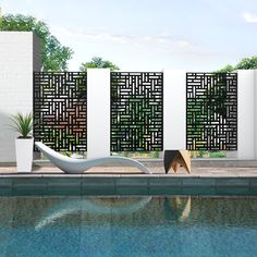 an outdoor swimming pool with a white fence and planter next to it, surrounded by greenery