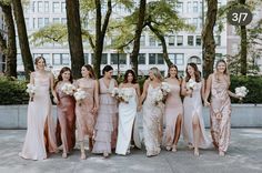 a group of women standing next to each other in front of some trees and buildings