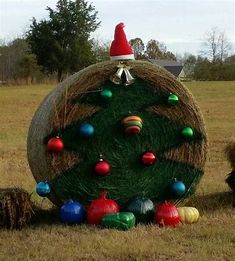 a large hay bale with christmas decorations on it in the middle of a field