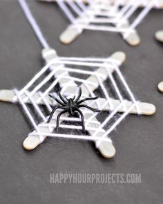 four spider webs are placed next to each other on a table with black and white decorations